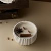 Vela_artesanal_resina_Chai_Latte Vela artesanal de Chai Latte decorada con anís y un palo de canela. Es una vela blanca en un recipiente blanco de resina con dos mechas de madera.